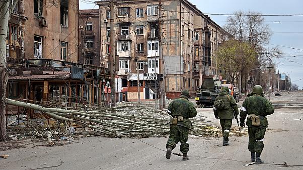 来自Do的民兵涅茨克人民共和国走过马里乌波尔科地区受损的公寓楼