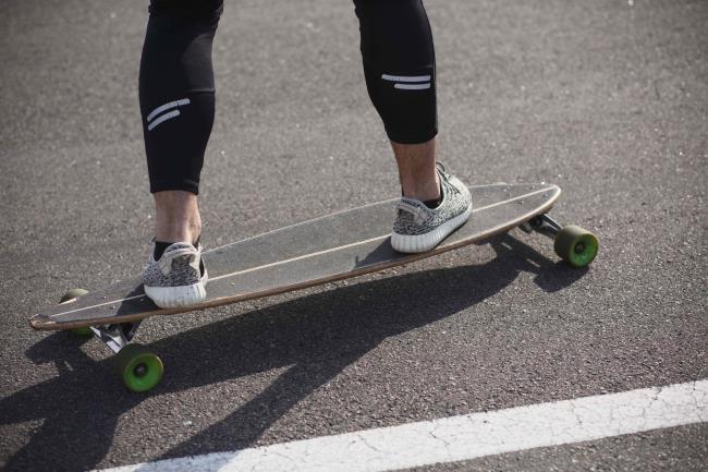 Man riding on lo<em></em>ngboard skate on road
