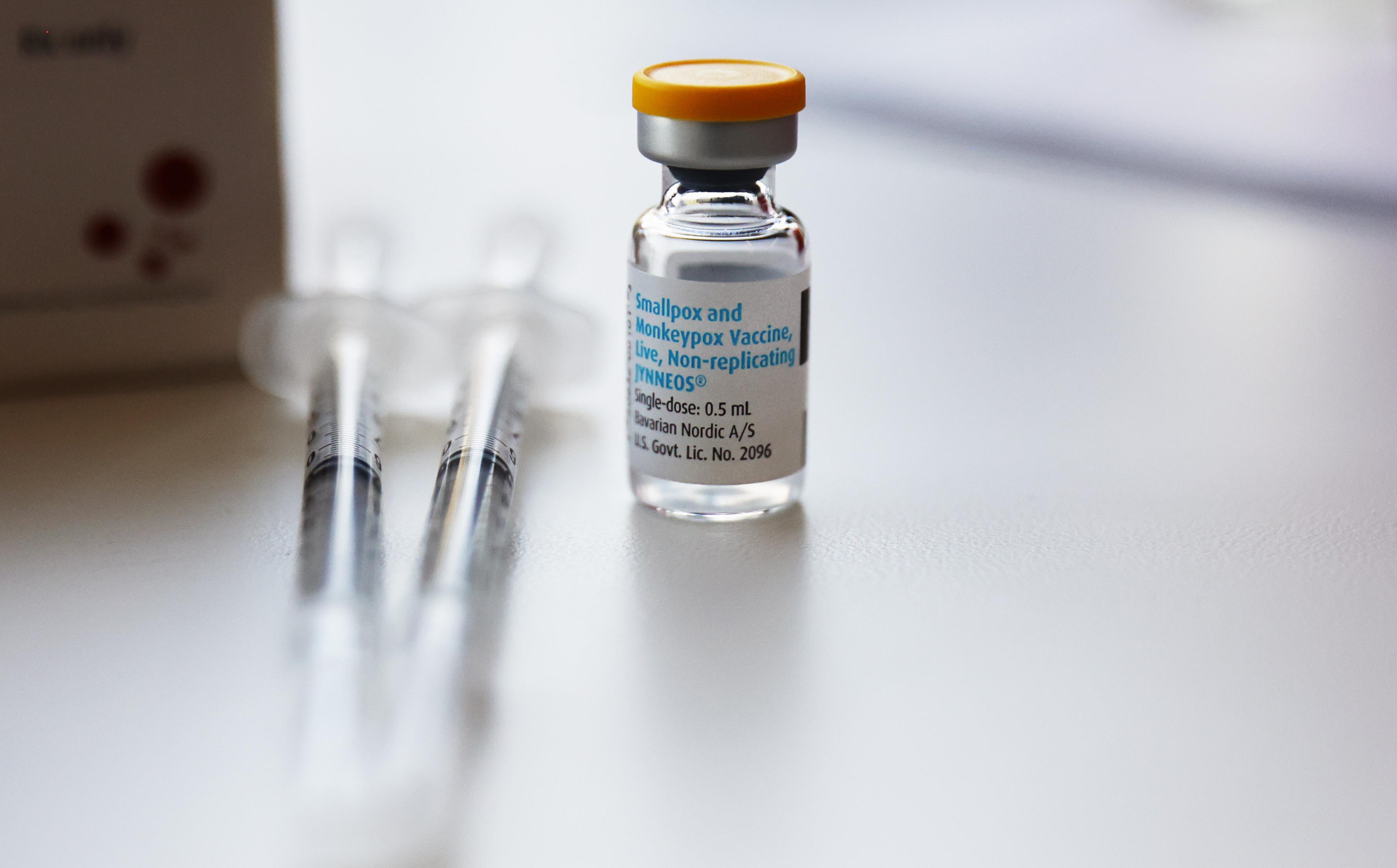 A bottle of vaccine next to two syringes.