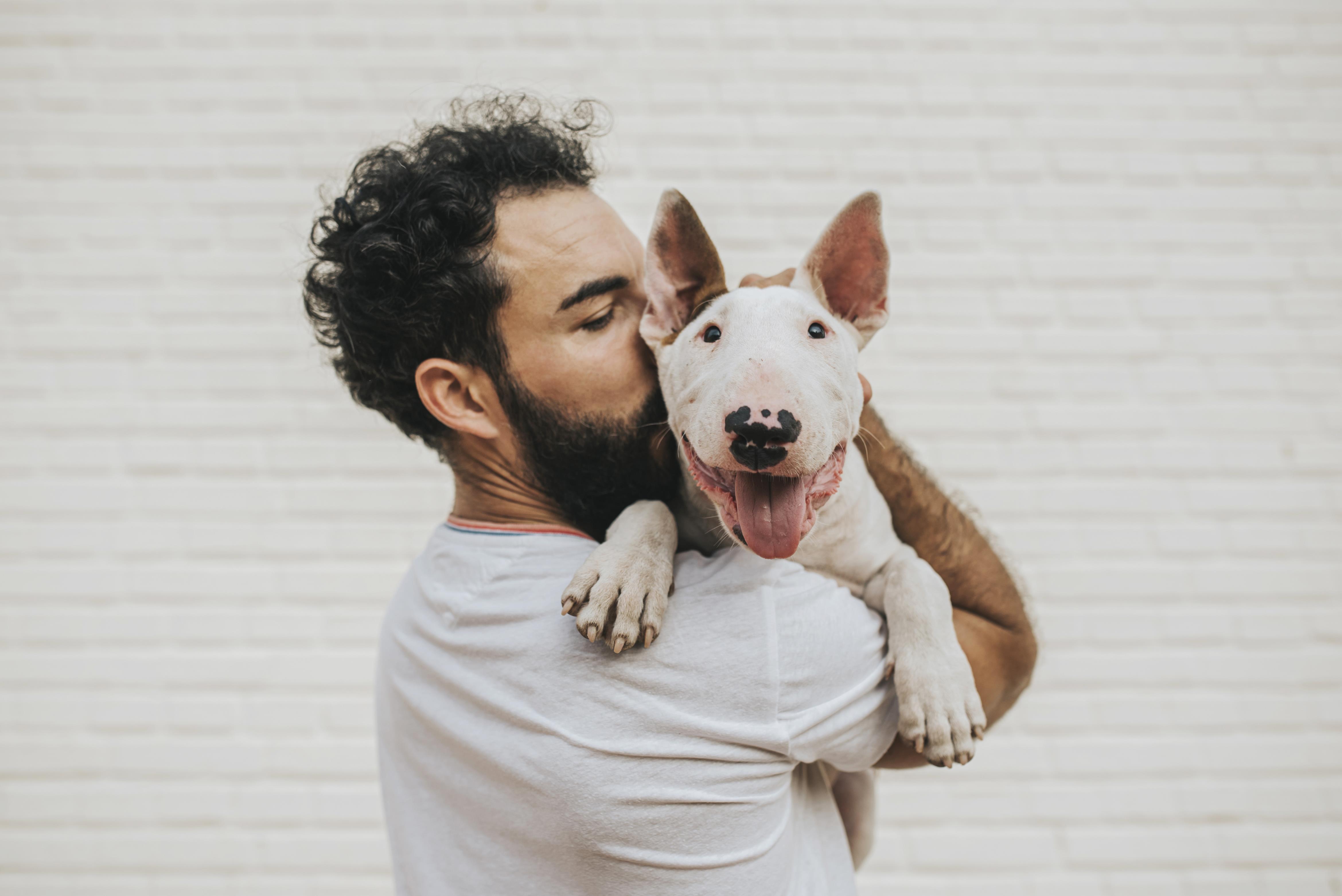 A man holding a dog in his arms.